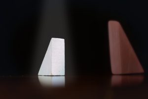 image of two triangular shaped blocks of wood, one white and the other brown