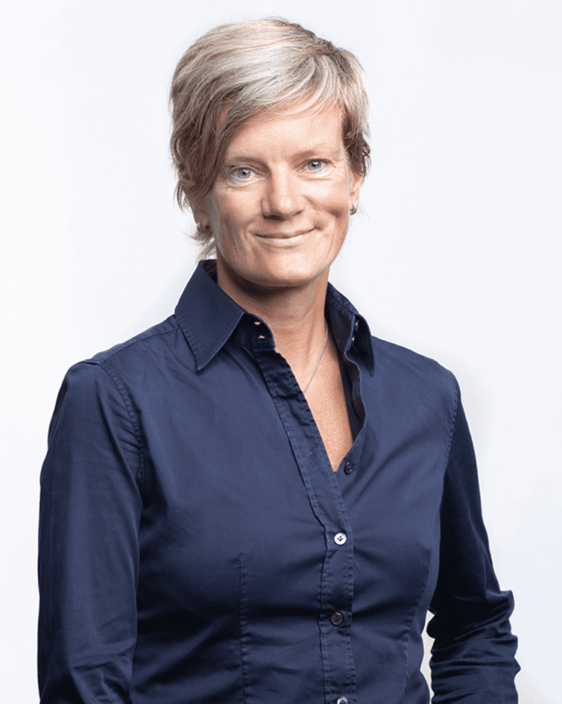 Hugoline van Hoorn photograph, wearing dark blue button up shirt, looking ahead