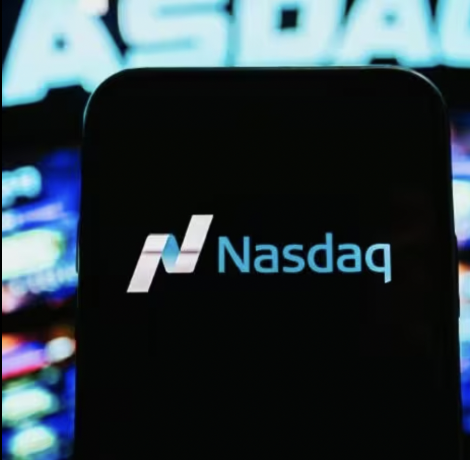 The Nasdaq logo on a black smart phone screen in front of a Nasdaq sign.